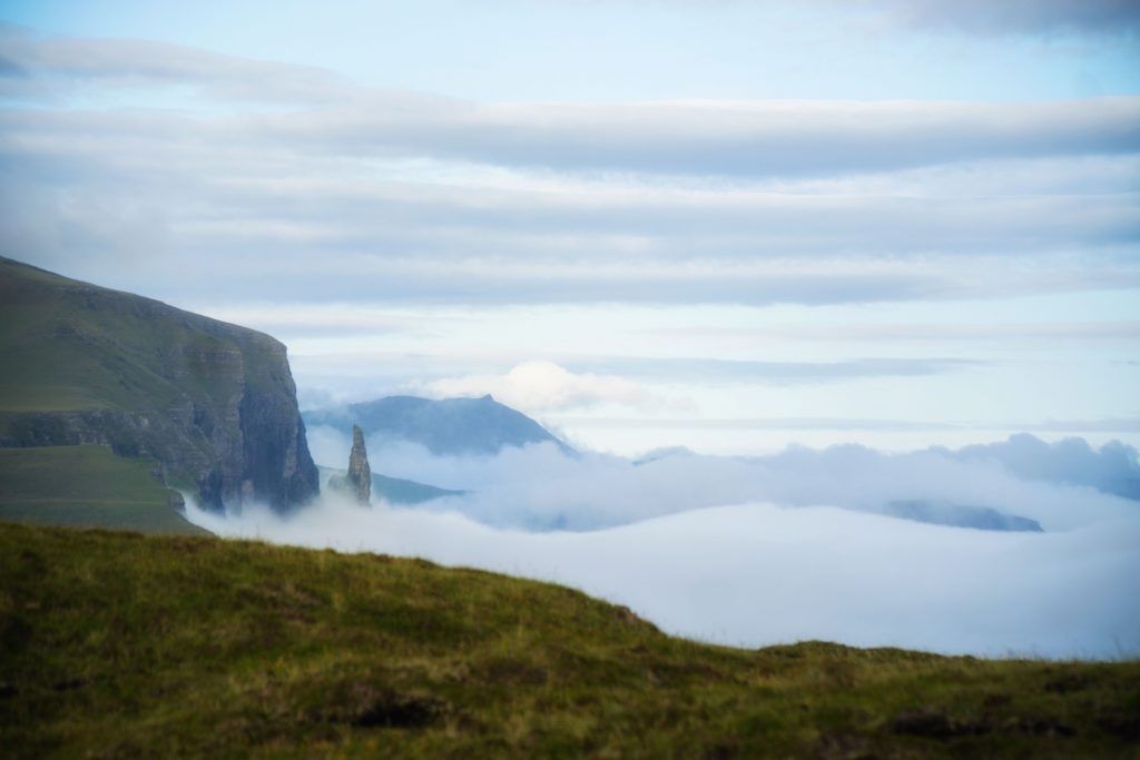 view of small rocky outcropping surrounded by fog