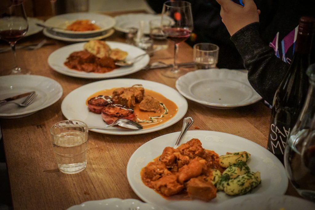 View of different kinds of Hungarian stews and foods that you might eat in Budapest in winter, like a paprika-based chicken stew, served with potatoes and dumplings.