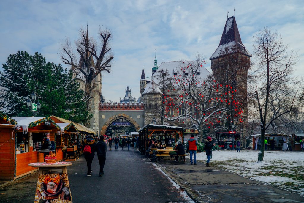 The christmas market all set up and festive in front of the vajdahunyad castle in one of the parks in Hungary’s capital city of Budapest in winter