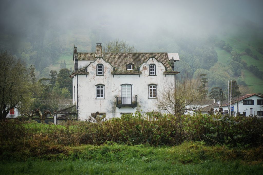 a dilapidated house with lots of fog around it