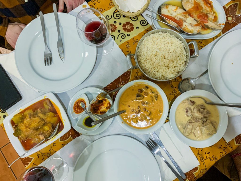 mozambican curries, rice, and fish set out at a table for three in porto