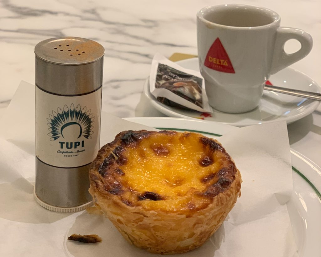 Eating a pastel de nata in a bakery in porto, portugal