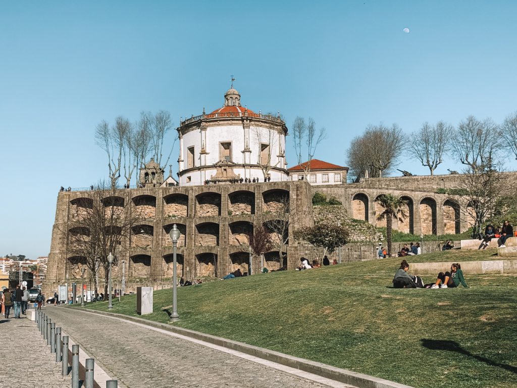 people sitting on the grass in front of the mosteira da serra