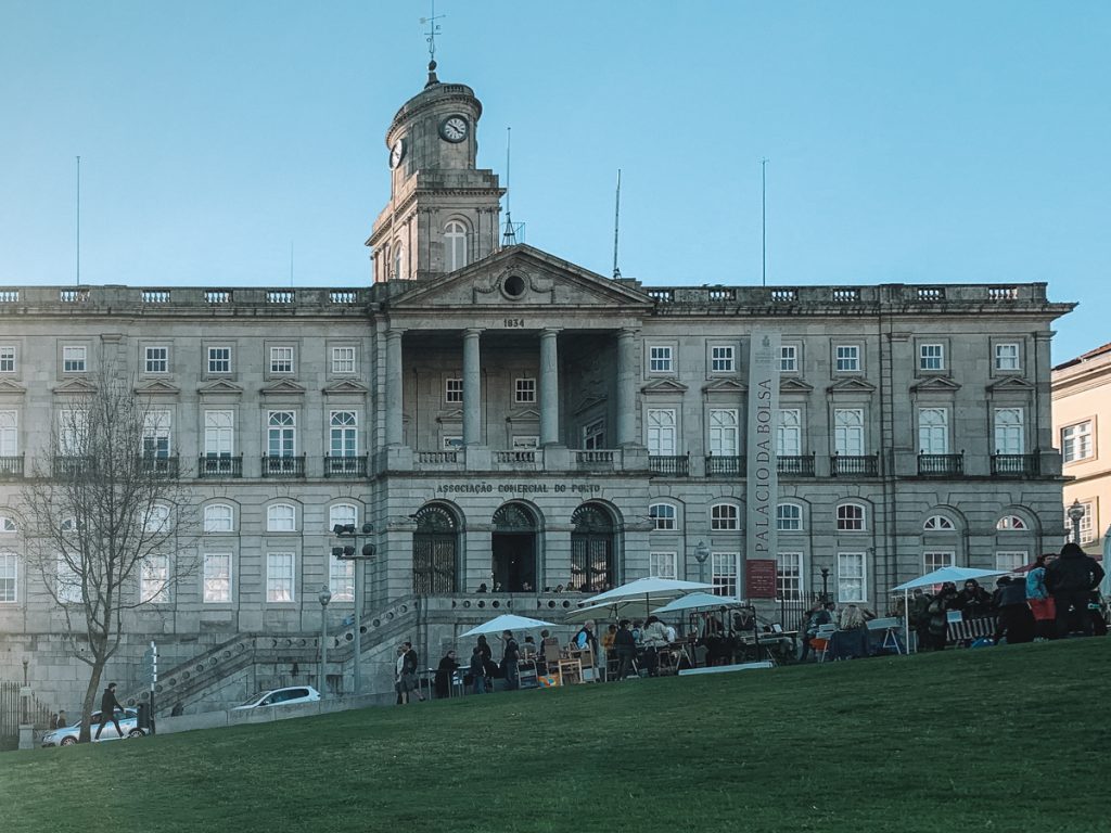 one of the buildings in the praca da ribeira area with a government building next to some grass in a park