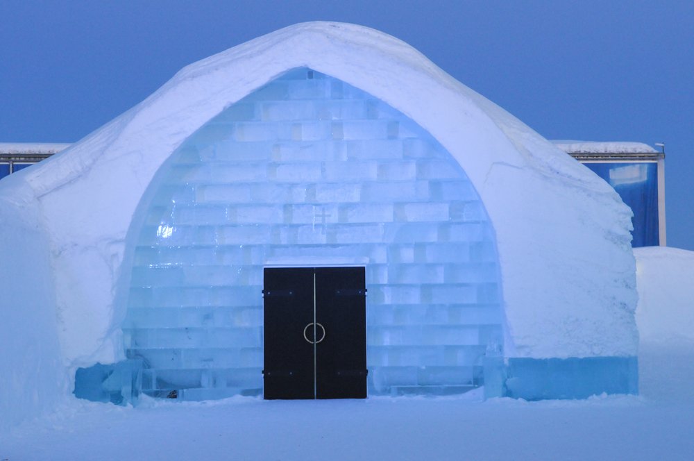 The doors to enter the Ice Hotel in Sweden, made with giant blocks of ice, and a wooden door.