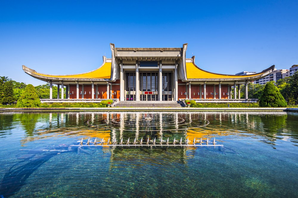 a beautifully symmetrical concert hall with a reflecting pool in front