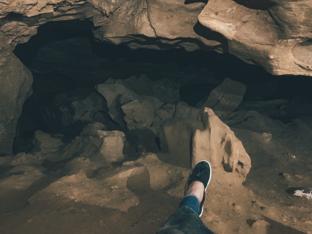 Allison Green showing what she was wearing on her Budapest cave tour: jeans underneath a pair of caving overalls and black sneakers