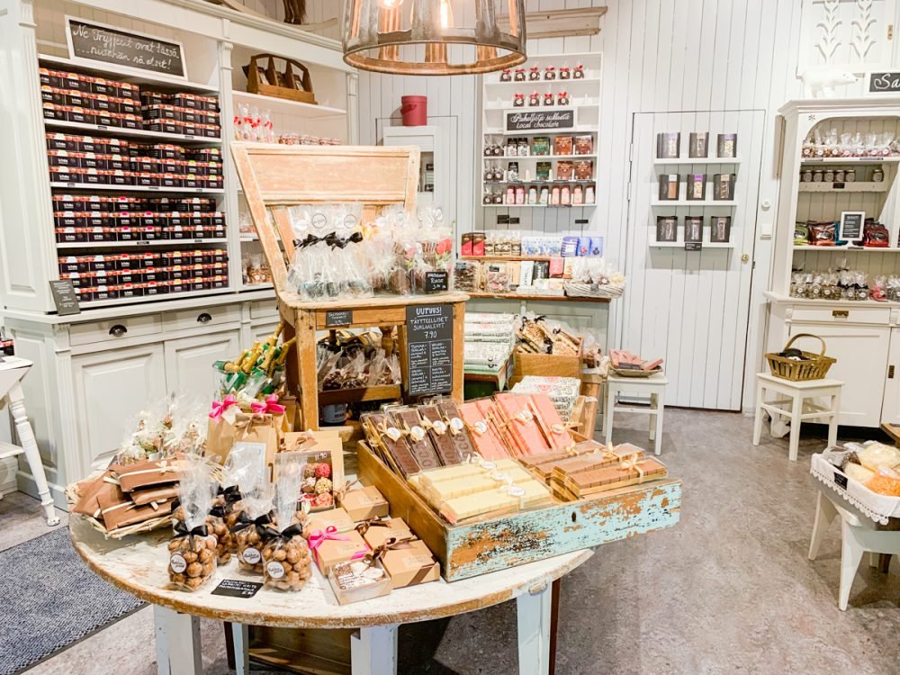 a selection of chocolate bars and other chocolate treats packaged beautifully in a white-decor room in tampere chocolate shop