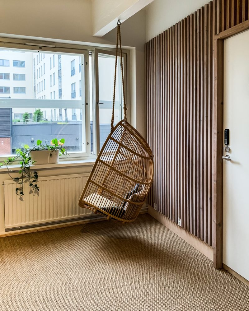 a wooden chair looking out the window at tampere city scape