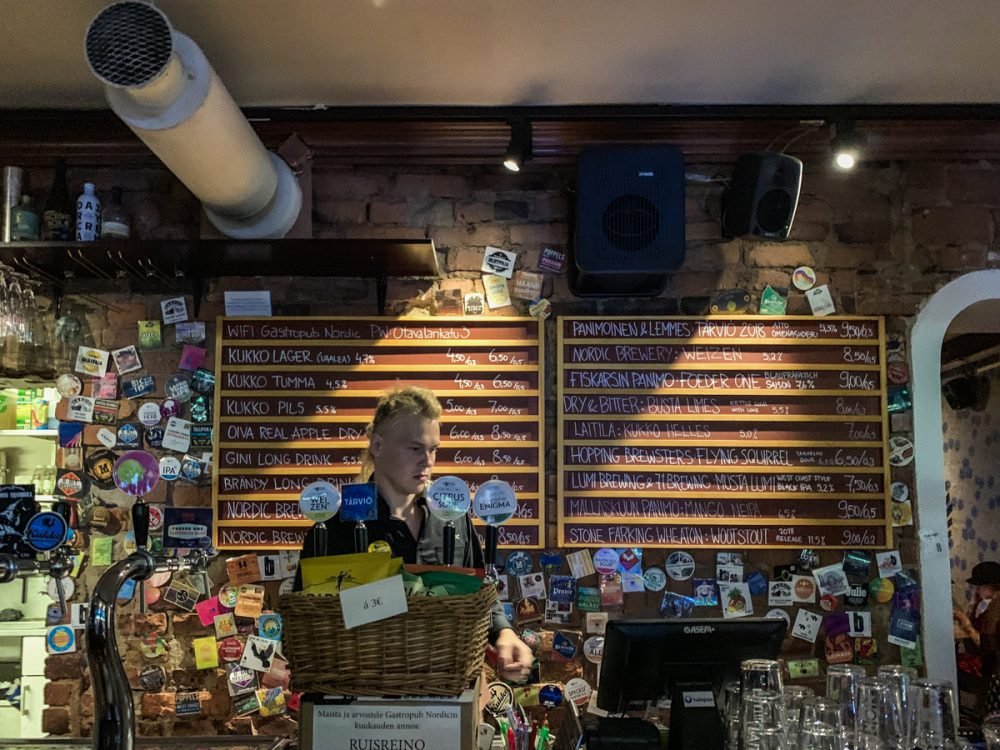 a beer bar at a restaurant with several taps and a person at the bar