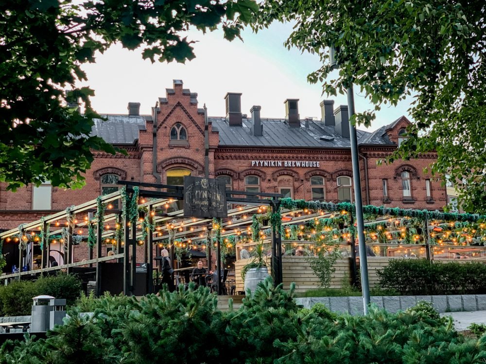 the pyynikin brewery in tampere with its outdoor beer garden all lit up and with vines