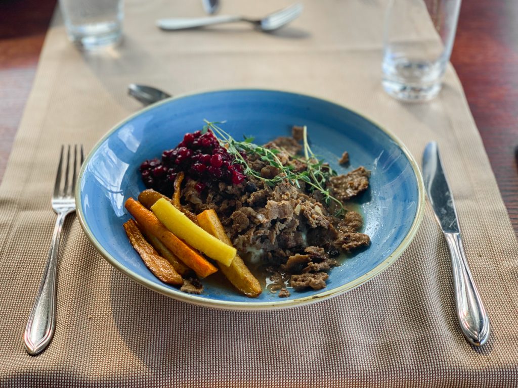a dish of reindeer meat, carrots, and lingonberry