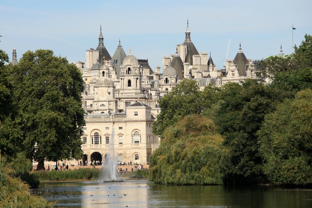 a calm park in the middle of london with a giant lake with water birds in the lake