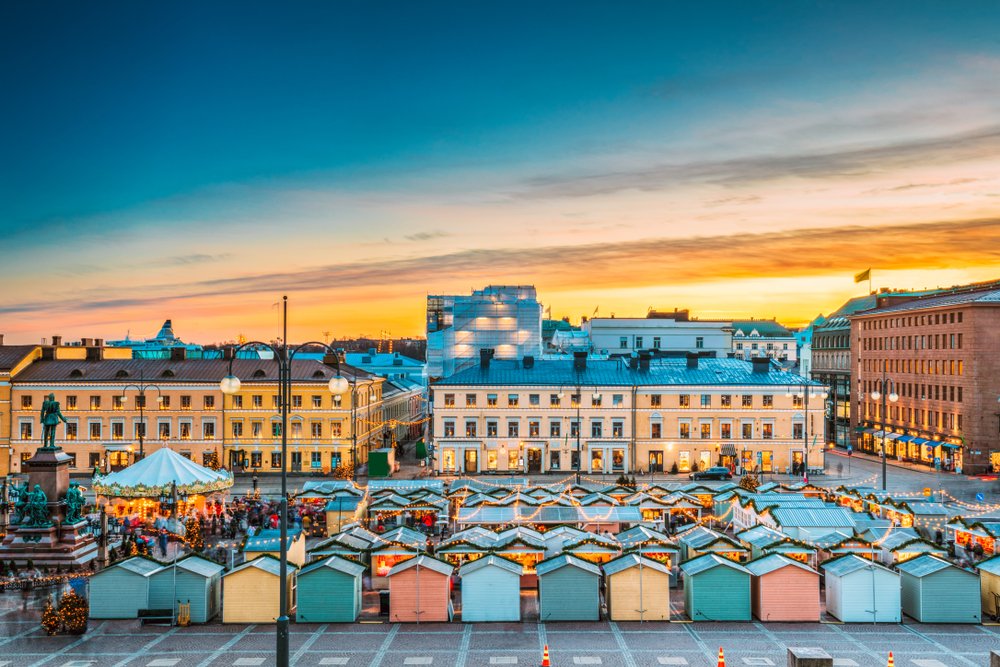 Adorable paste colored Christmas market stalls in baby blue, pink, yellow and green as the sun sets in Helsinki