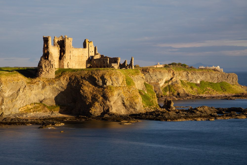 Cliffside castle on a rugged coastline and water