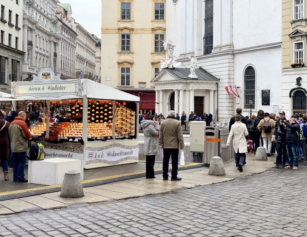 People in their winter clothing standing in the market in one of the main central areas of Vienna's downtown where there are lots of markets in the right season