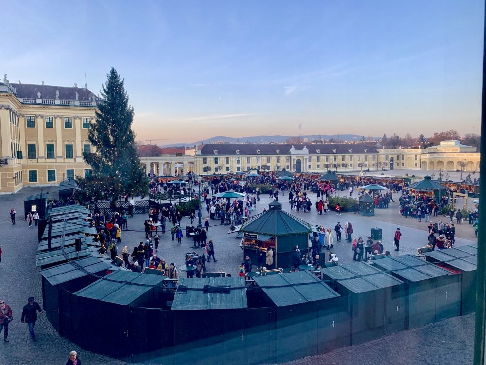 Looking out the window at the beautiful Schonbrunn palace and seeing all the Christmas market stalls below around the time of sunset