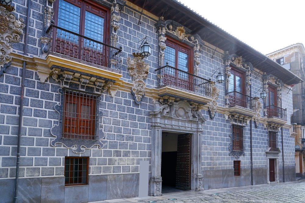 Historic facade of the Granada madraza with blueish-gray brickwork and detailed balconies