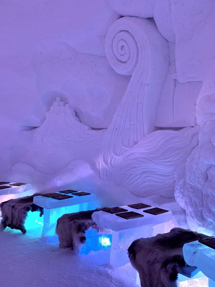 View of the tables at the Tromso Ice Dome with reindeer pelts and ice tables and place mats.