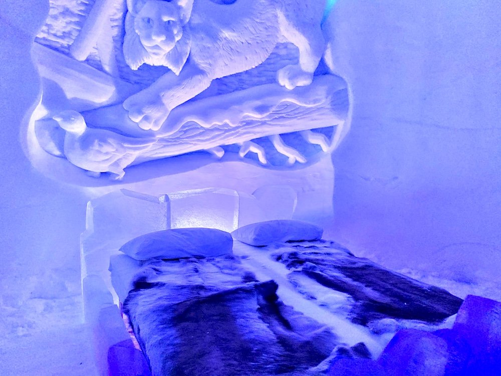 View of the bed at the Tromso ice domes with beautiful ice carving above the bed