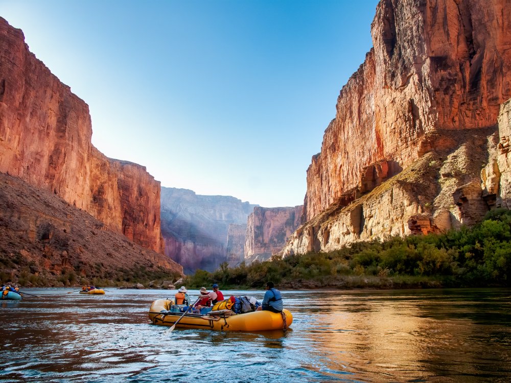 people rafting on the colorado river which is part of the grand canyon around the sunrise hours