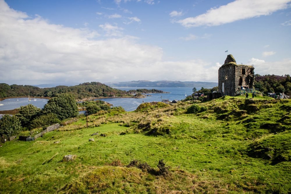 Gorgeous green scottish landscape with castle ruins and bay