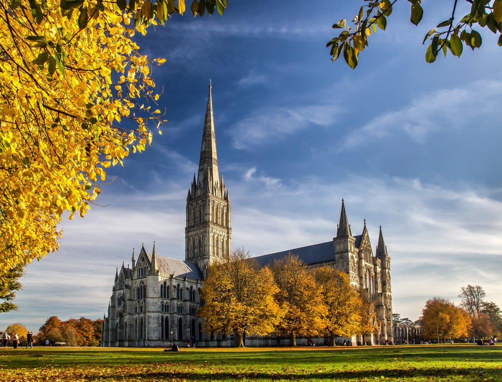 beautiful town in england on a road trip through europe in the fall with yellow leaves and church