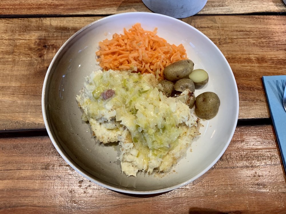 A fish casserole with boiled potatoes and carrot salad