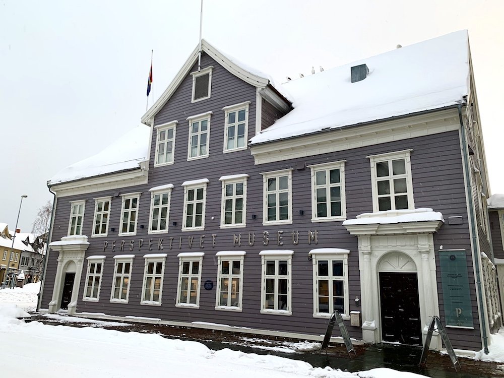 a grey wood building called the pespective museum in tromso, norway