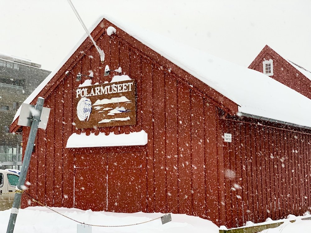 Red polar museum building with snow falling in front of it