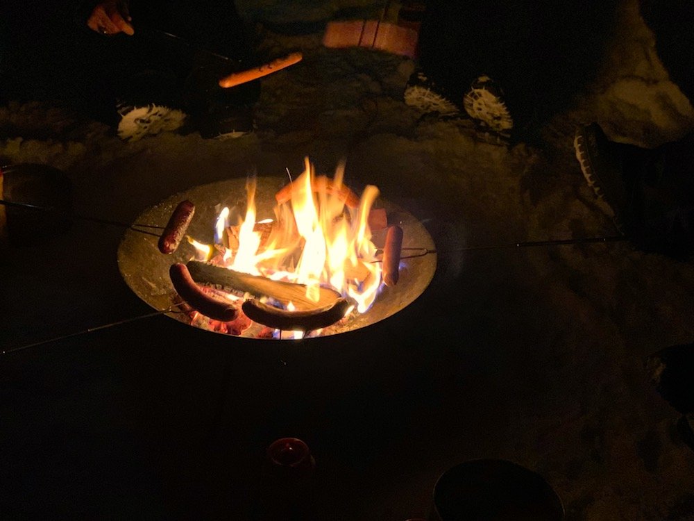 Allison cooking sausages over an open fire