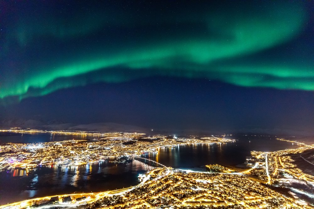 Northern lights over the city of Tromso as seen from the viewing platform at Fjellheisen cable car