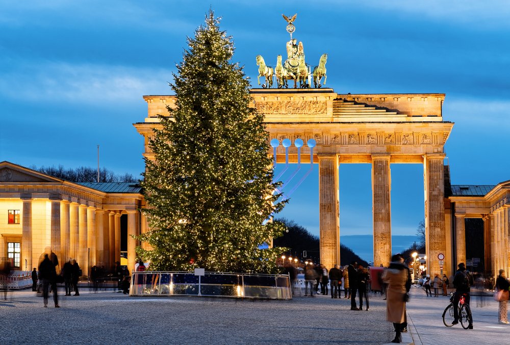 the brandenburg gate in berlin germany with a christmas tree in front of it