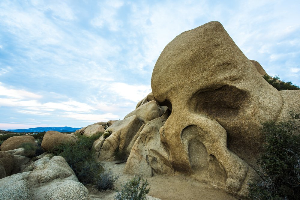 A rock shaped like a skull on a partly cloudy day on this Joshua National Park 2 day itinerary.