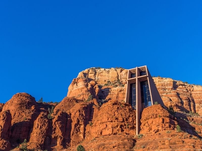 A church in the red rocks of Sedona with a large cross and stained glass