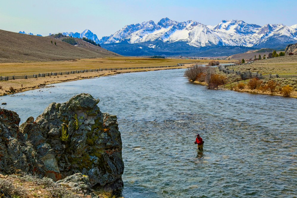 View of a river with mountains surrounding it on a clear sunny day.