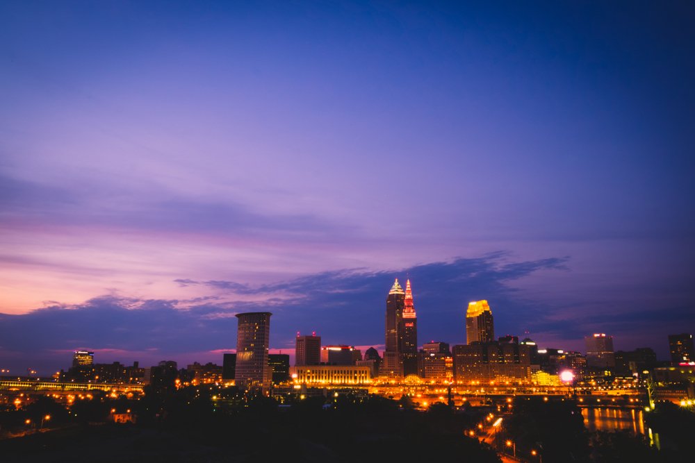 The view of the Bozeman skyline at night, with a purplish pink sky just after sunset, with all the buildings lit up for nighttime.