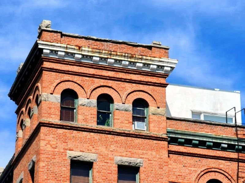 Architecture in downtown Bozeman, a hotel made of brick with a fire escape and distinctive arched windows