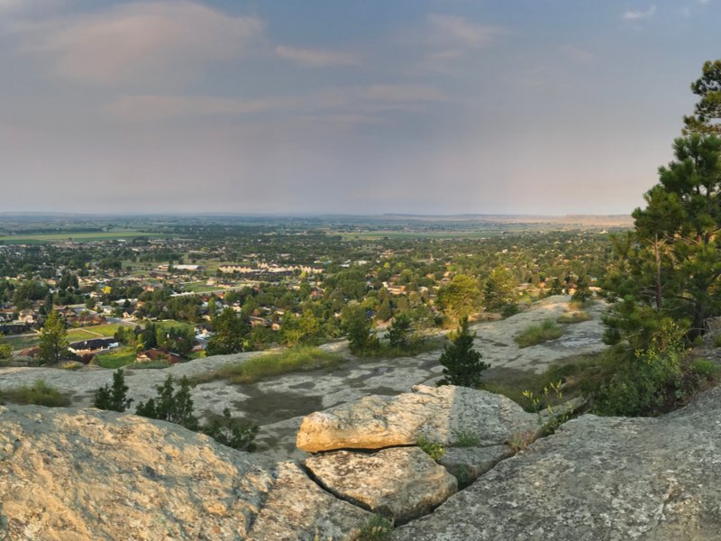 View from rocks and trees above the city of Billings from a local hike around sunset