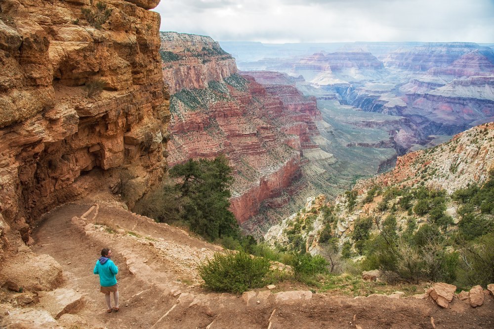 Woman hiking below the Rim in the Grand Canyon wearing a blue jacket.