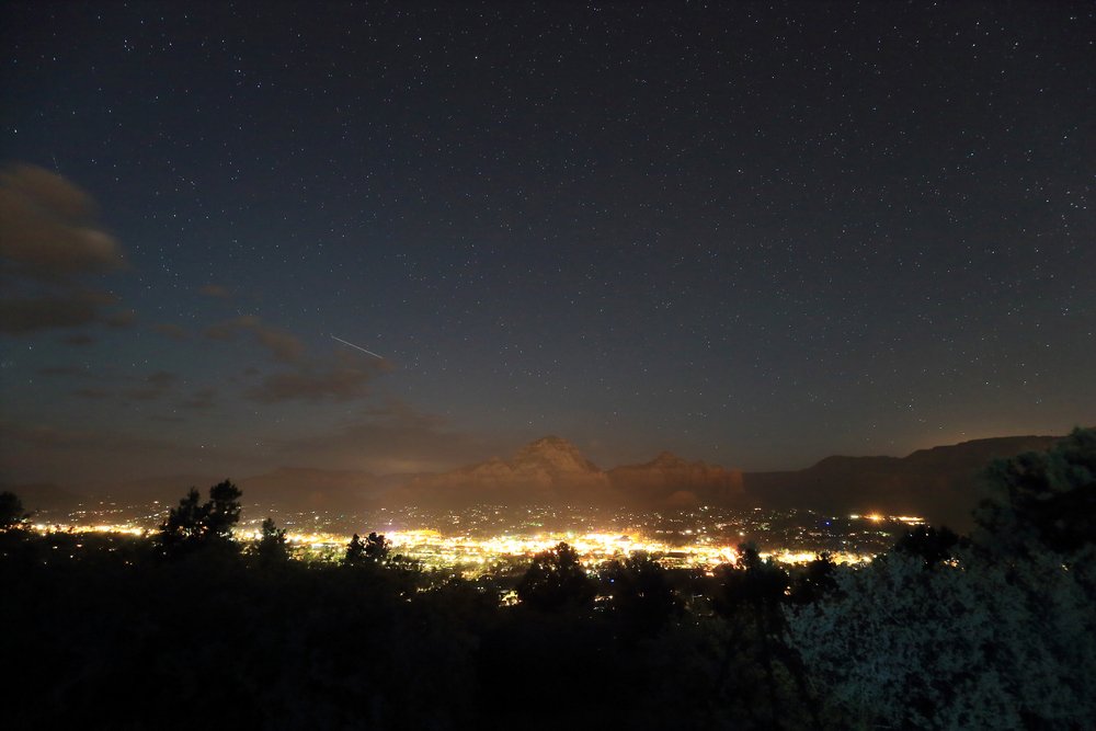 Stargazing at Airport Mesa - sky in Sedona at night with the city lights off in the distance.