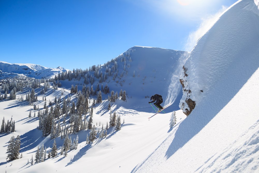 A man doing a jump while backcountry skiing in Jackson