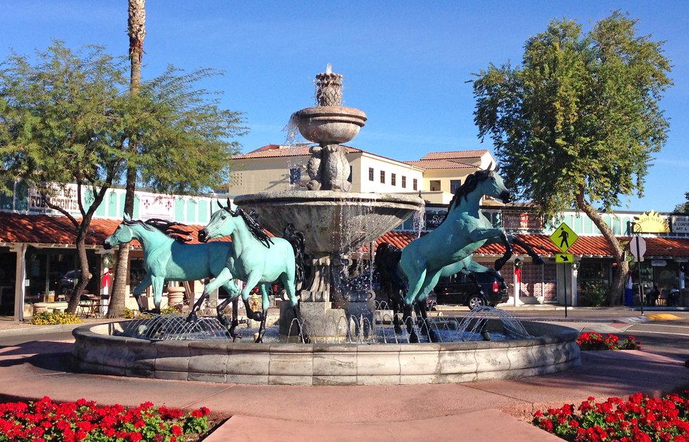 Square in Old Town Scottsdale with three greenish turquoise horses in a water fountain