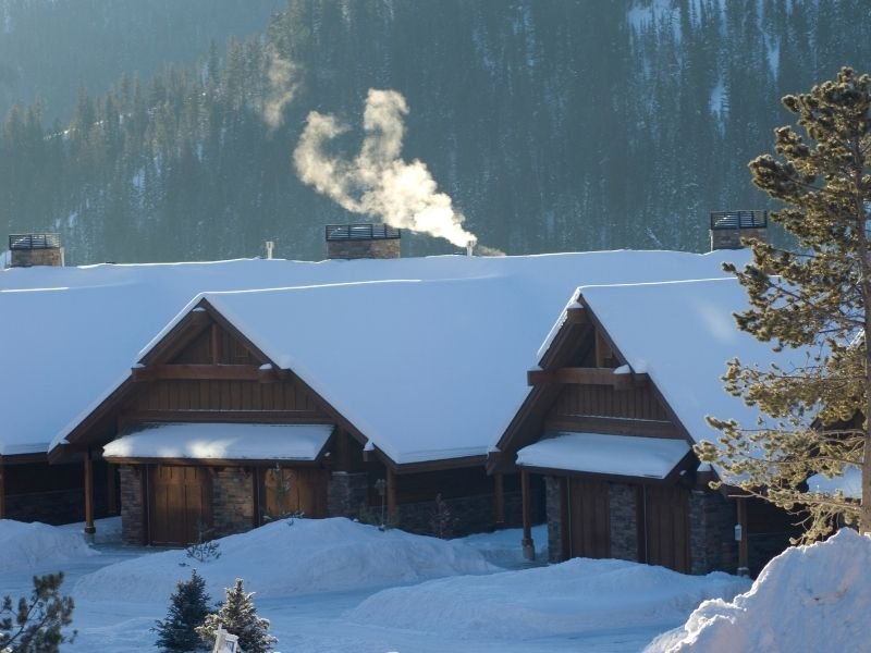 Cabin views of Big Sky Montana covered in snow on a wintery day with the sun out