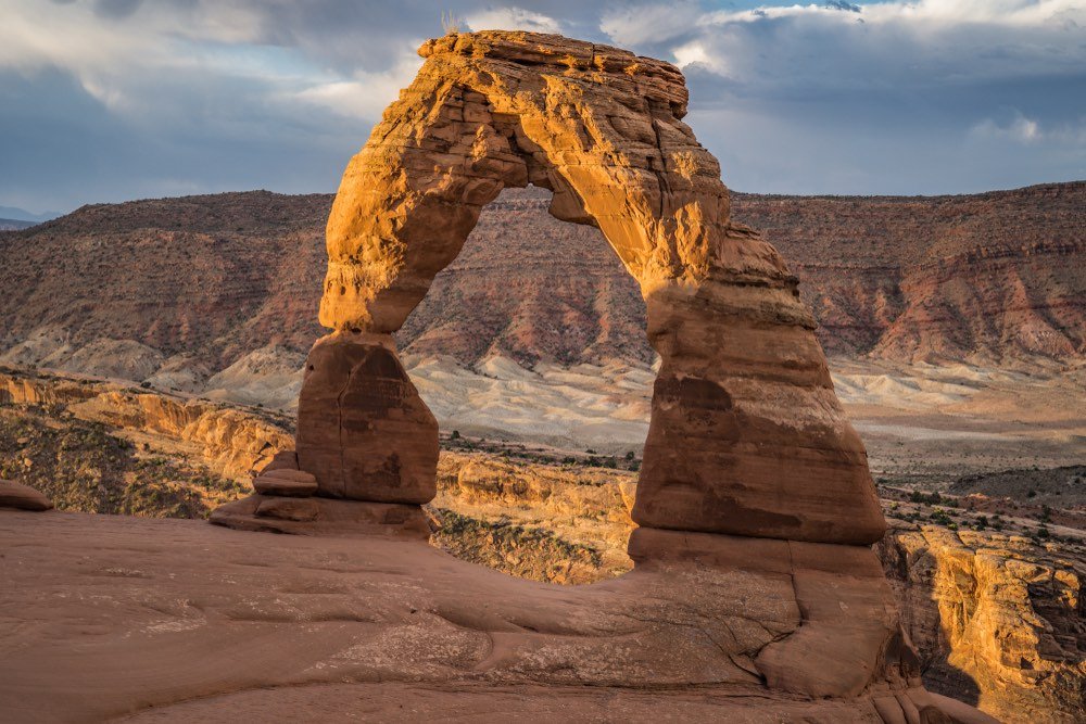 A view of the famous Delicate Arch, a Utah road trip must, taken at sunrise with the light falling on the left side of the arch.