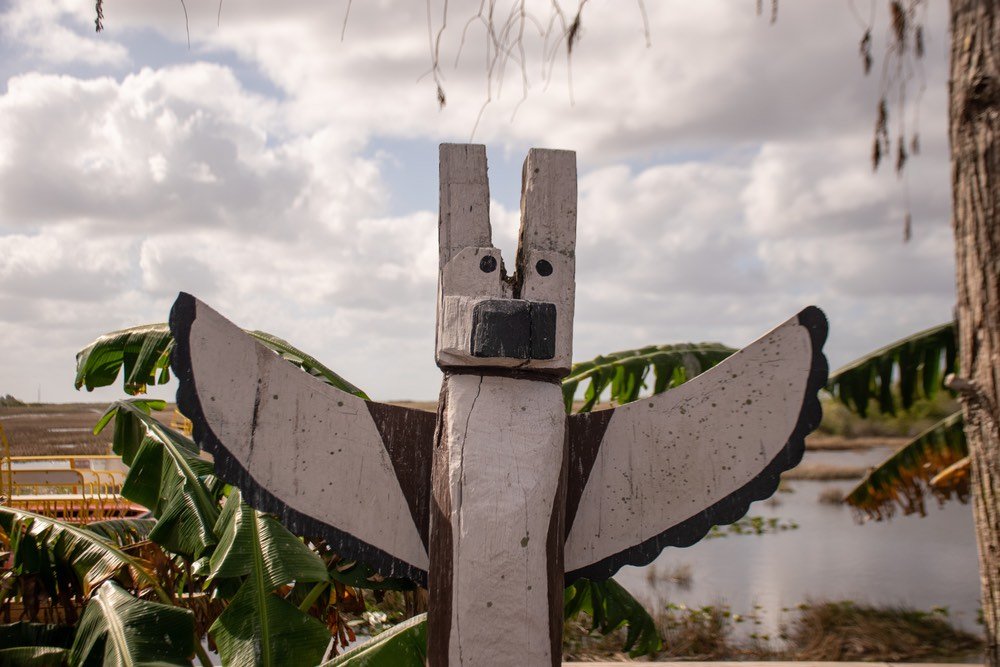 Traditional Miccosukee wooden totem shaped like a bird in a wetland scenery in Everglades, Florida