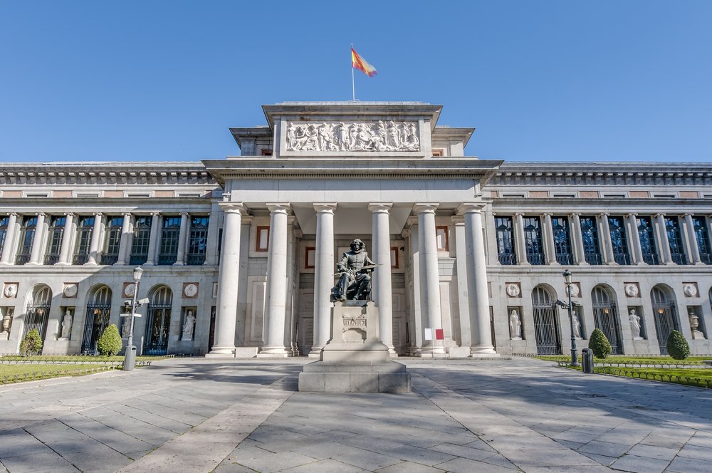 The front view of the famous Prado art museum with a statue in front, a must visit on your one day in Spain itinerary