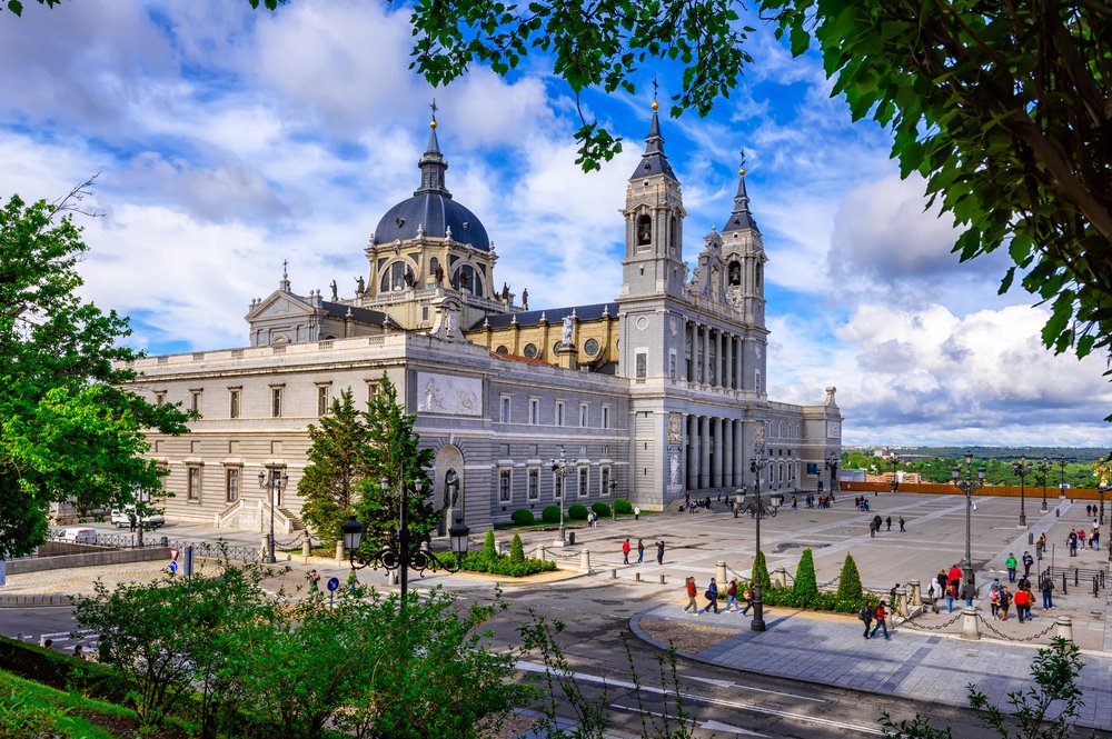 Side view of a beautiful European church with people walking around in front and a cloudy sky