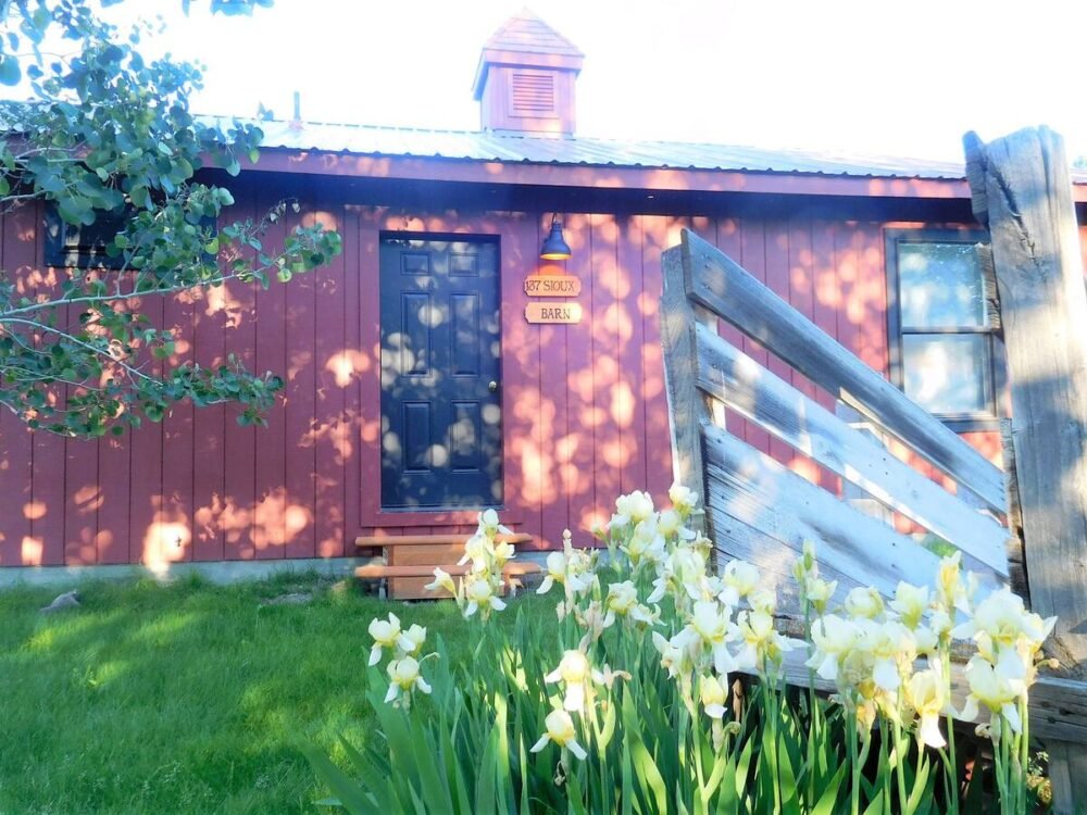 View of a red barn available for rent as an Airbnb.