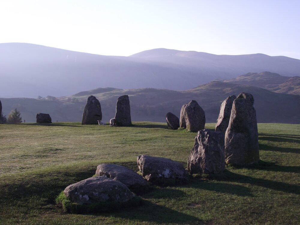 A circle of large stones casting a shadow in the late afternoon sunlight on Castlerigg in the Lake District.